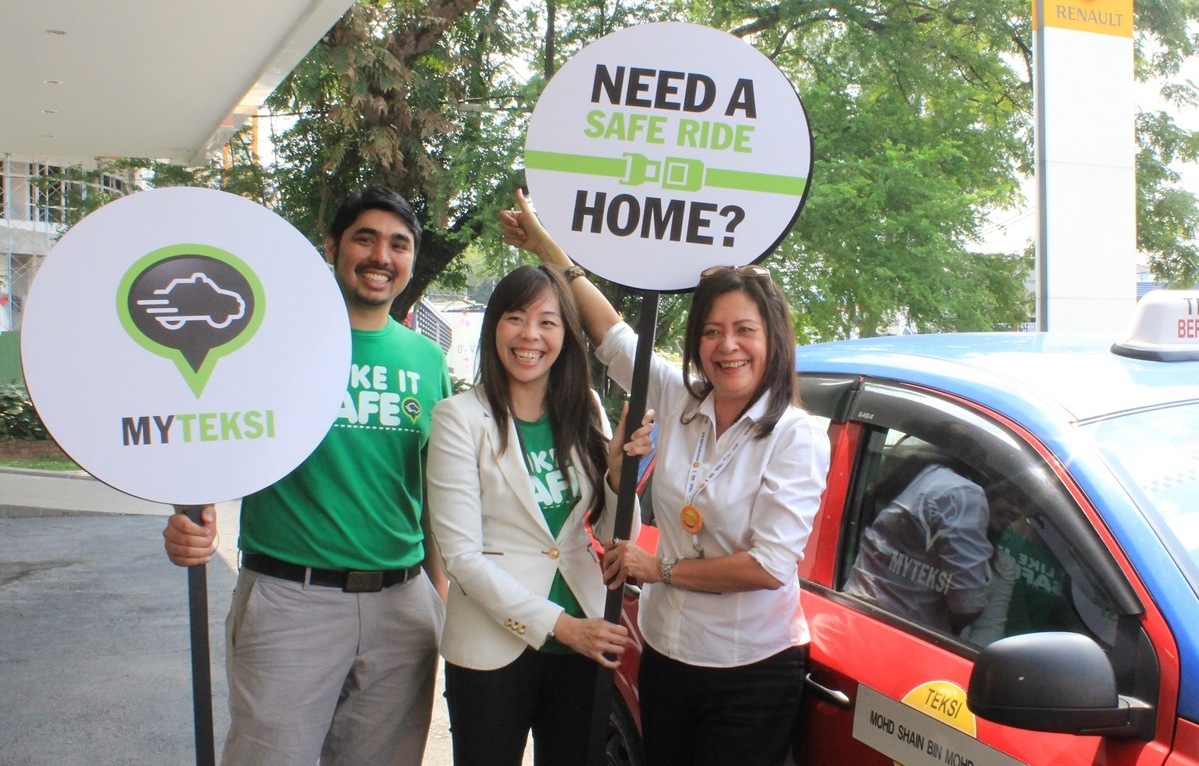 The MyTeksi team launching a road safety campaign. Aaran Gill (left) with Adelene Foo (middle) with an executive from a taxi company.