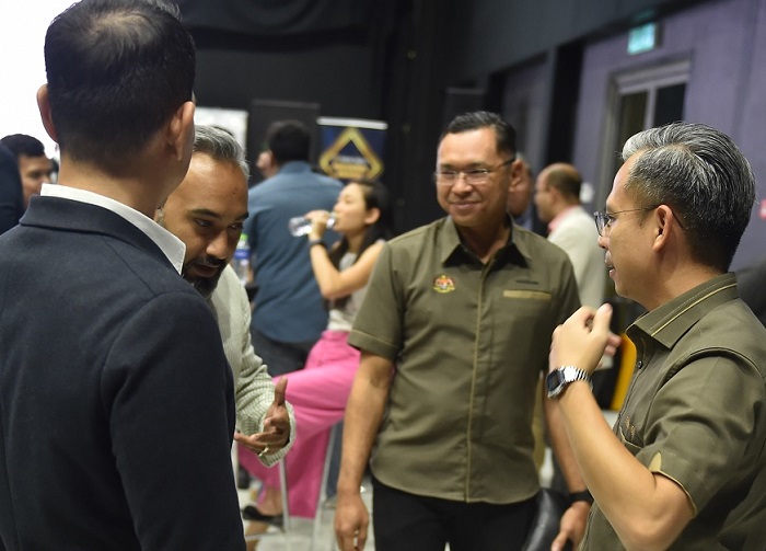 (From Left) Aaron Sarma (partially hidden), founding partner of Scaleup Malaysia making his point to Fahmi (right) as MDEC CEO Mahadhir Aziz listens on (centre).