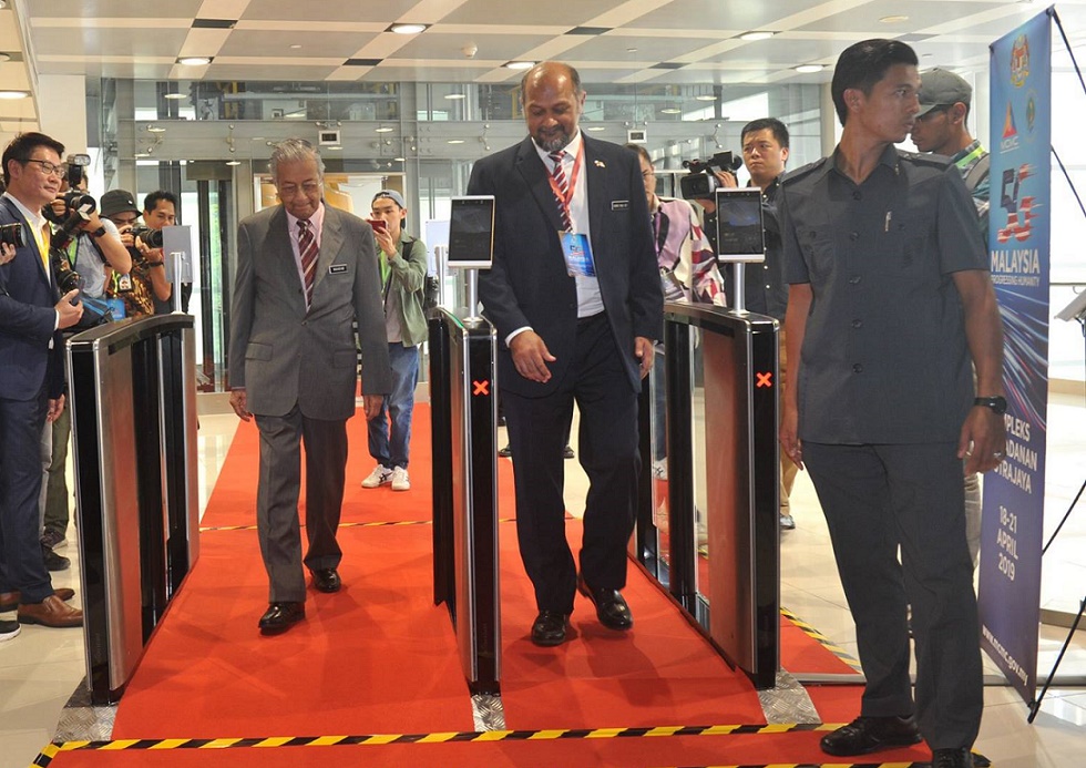 Mahathir and Gobind going through the facial recognition turnstiles.
