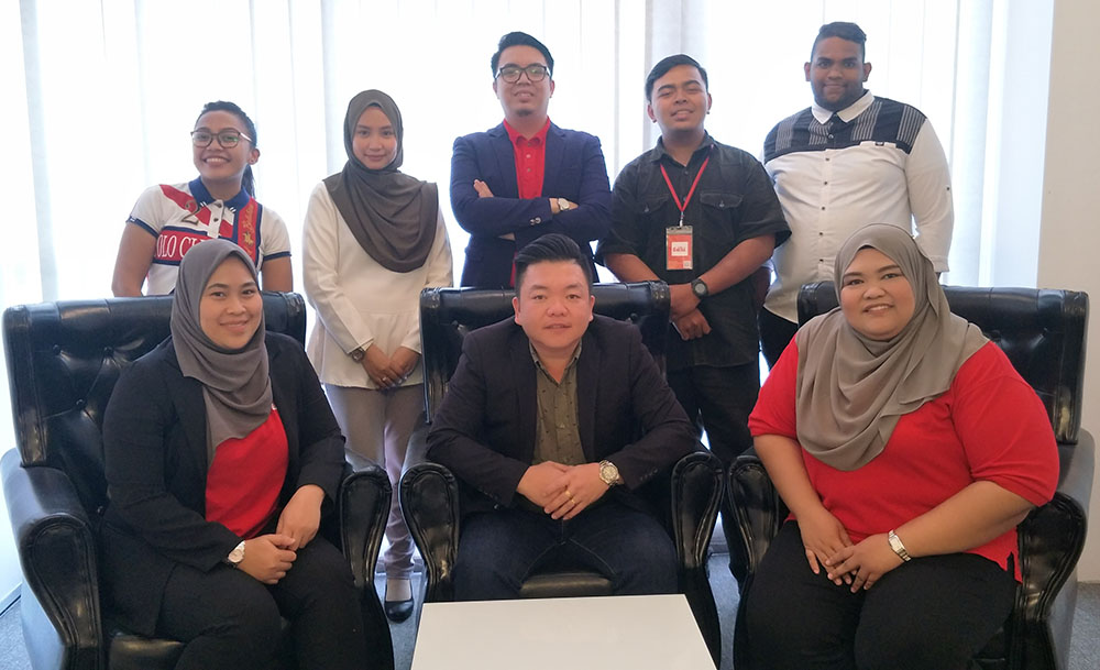 EaziCar co-founder and CEO Alex Teow Boon Heong (sitting, centre) with his team