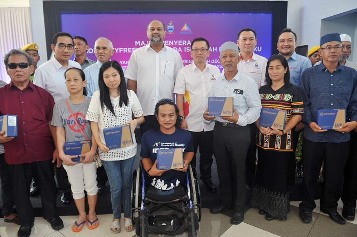 Gobind Singh Deo, second row, third from left, with some families in the B40 category in Sabah who received their decoders on Wed.