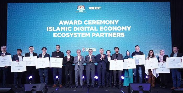 (6th from left) Mohamad Fauzi Isa, Secretary General, Ministry of Communications and Digital; Fahmi Fadzil, Minister of Communications and Digital; Syed Ibrahim Syed Noh, Chairman of MDEC; and Ts. Mahadhir Aziz, CEO of MDEC, posing with the industry players who received recognition as IDE ecosystem partners.