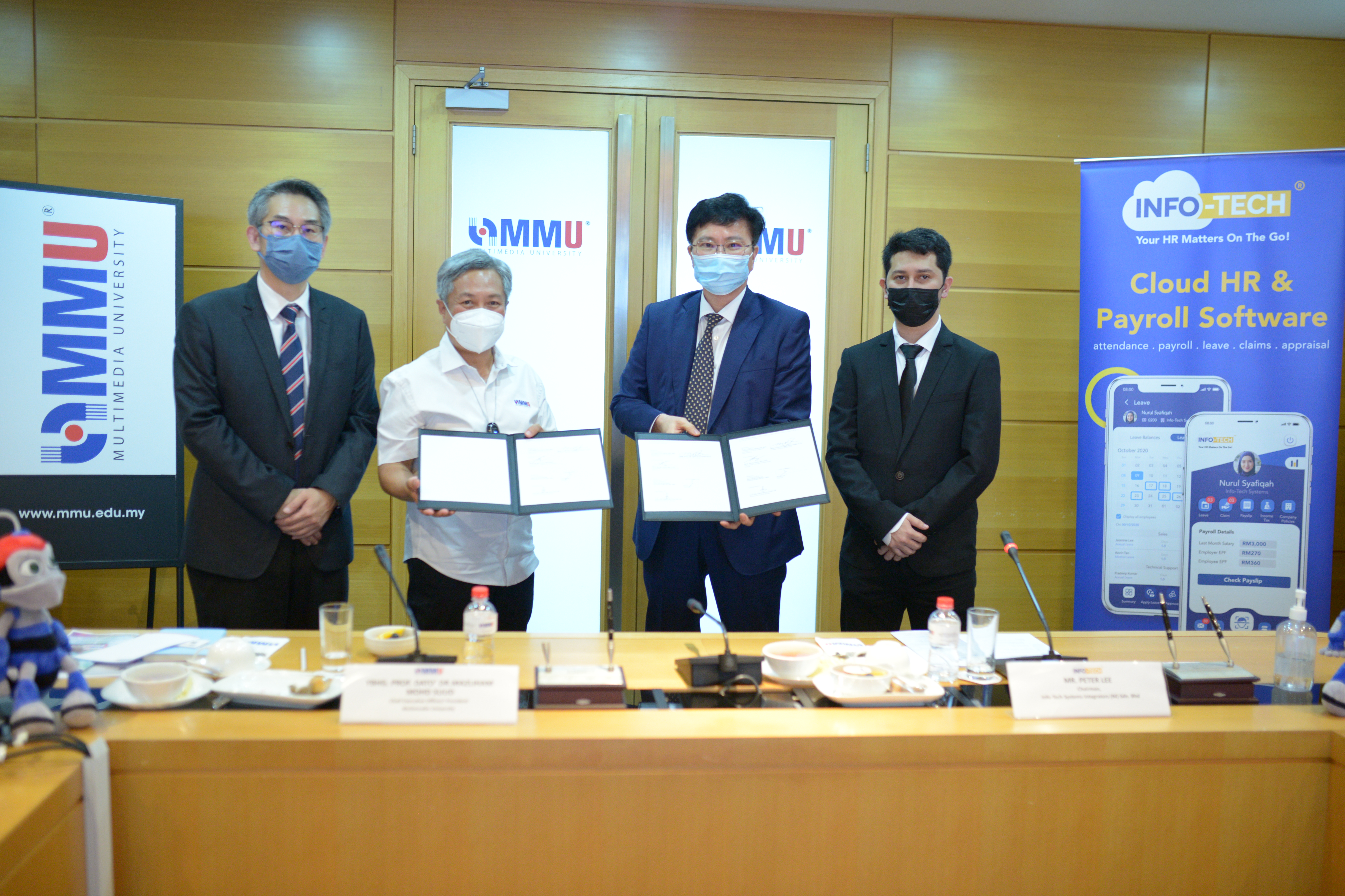  Info Tech - Prof Dato Dr Mazliham Mohd Suud (second from left) and Mr Peter Lim (right) exhanging MoU documents at the MoU Signing Ceremony at MMU Cyberjaya