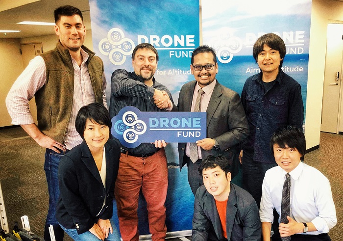 Kamarul Muhamed, standing, 2nd from right, shaking hands with Soki Ohmae, board member of Drone Fund. Kotara Chiba, founder and general partner is to his left.