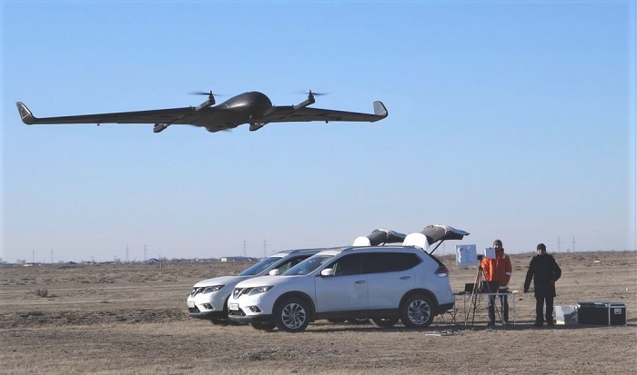 Aerodyne Caspian staff in the field with an UAV above.