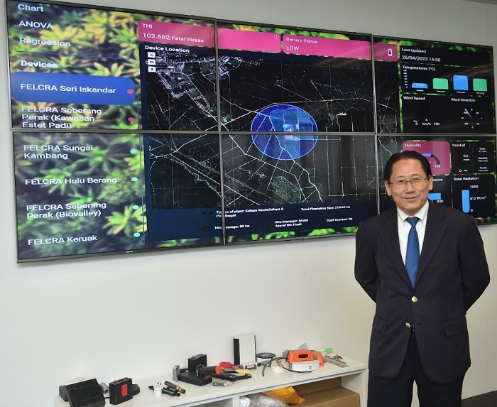 Liew posing against a live screen monitoring a client's farm.