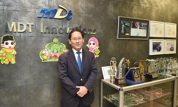 Liew posing with some of the many awards he received for MDTI.