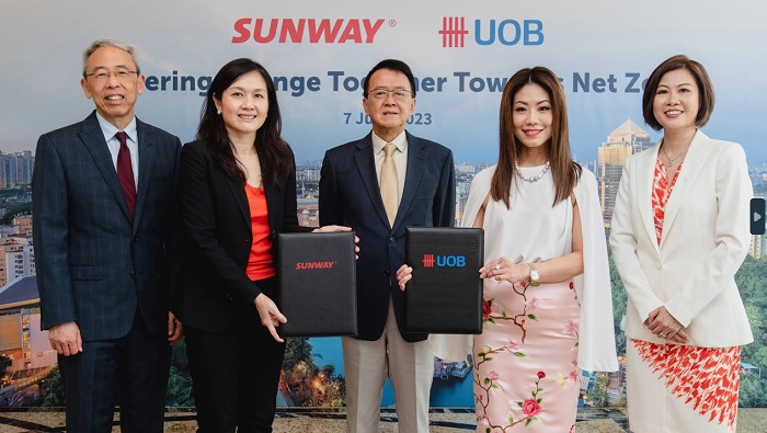 Sunway Group founder and chairman Dr Jeffrey Cheah (centre) looks on as Sunway Group executive director Sarena Cheah (second from left) and UOB Malaysia CEO Ng Wei Wei (2nd from right) exchange documents in a partnership to advance net zero efforts, flanked by Sunway Group CFO Chong Chang Choong (left) and UOB Malaysia Corporate Banking country head, Wholesale Banking, Anita Tang (right).