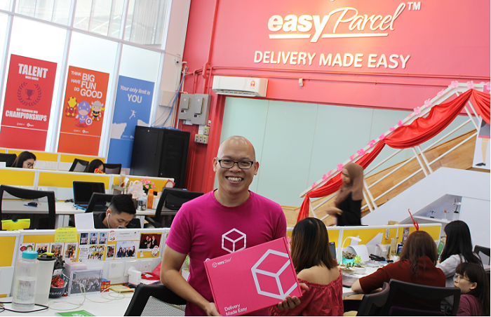 Clarence Leong in the Penang office of EasyParcel. He is holding a gift box that customers who purchase US$490 (RM2,000) worth of pre-paid credit, receive as a complimentary gift. It includes a weighing scale that can handle a max weight of 5kg, the maximum weight for most eCommerce parcels.